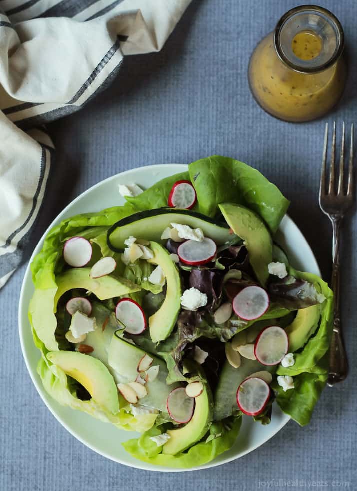 A simple fresh Summer salad that takes 5 minutes - Avocado Butter Lettuce Salad filled with spicy radishes, almond slices, goat cheese, and topped with a Lemon Vinaigrette. | joyfulhealthyeats.com #recipe #glutenfree #vegetarian 鲕梨黄油莴苣沙拉顶视图