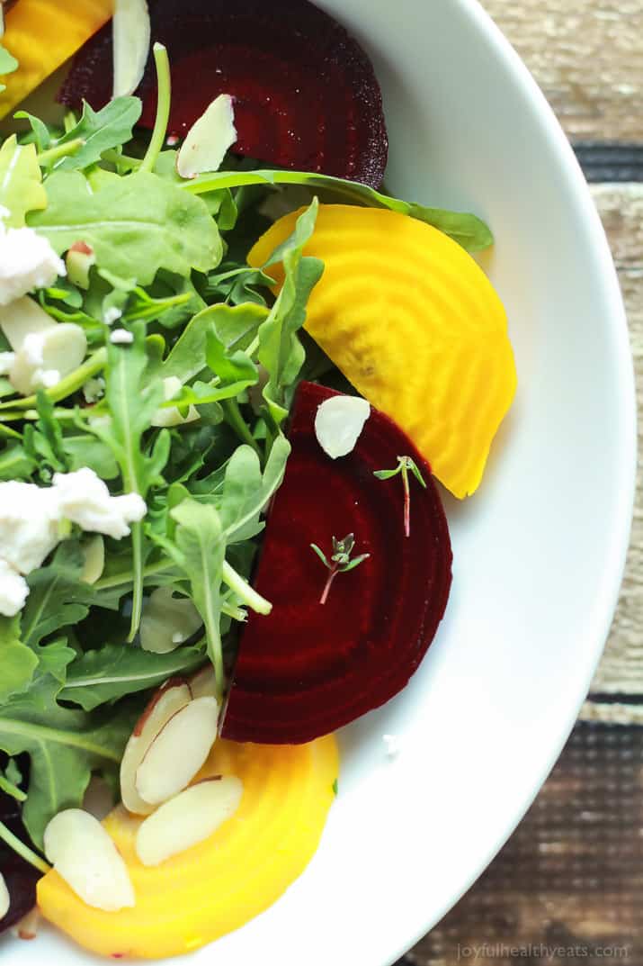 Roasted Beet Arugula Salad with sliced almonds, fresh thyme, and creamy goat cheese then drizzled with a honey dijon vinaigrette - the perfect light salad for your weekend party! Takes minutes to make! | joyfulhealthyeats.com #recipes #vegetarian #glutenfree 烤甜菜芝麻菜沙拉,杏仁片,新鲜百里香,奶油山羊奶酪,然后再淋上蜂蜜第乔恩油醋汁——周末派对上完美的清淡沙拉!只需几分钟!| joyfulhealthyeats.com #食谱#素食#无麸质