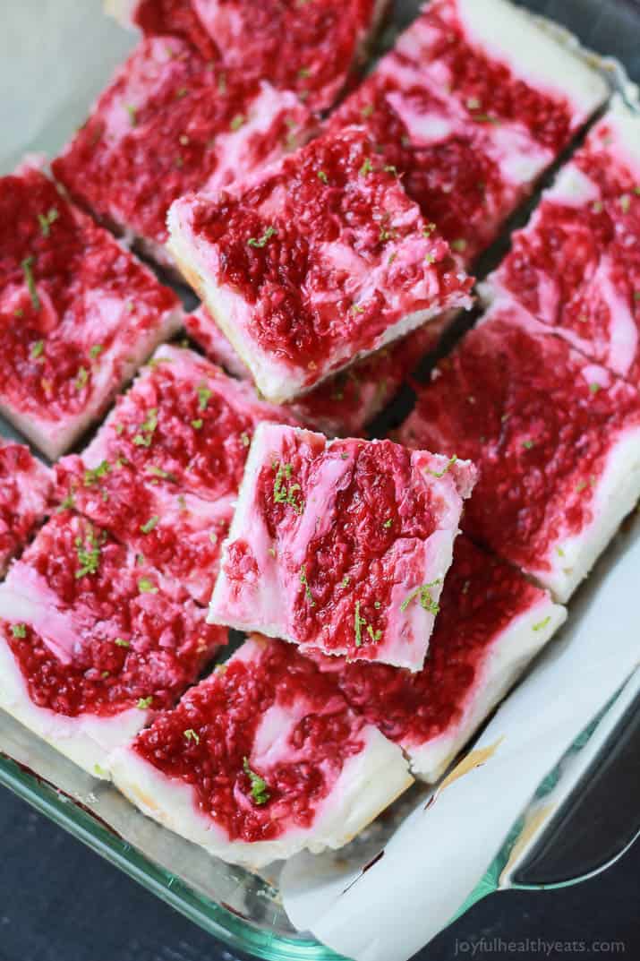 Skinny Raspberry Mojito Cheesecake Bars filled with creamy cheesecake goodness, fresh mint and lime juice, then topped with a fresh raspberry compote - only 130 calories! Perfect for summer parties! | joyfulhealthyeats.com #RaspberryDessert #Driscollsberry #ad 薄覆盆子莫吉托芝士蛋糕条充满了奶油芝士蛋糕,新鲜的薄荷和酸橙汁,然后顶部是新鲜的覆盆子果盘——只有130卡路里!非常适合夏季聚会!| joyfulhealthyeats.com #树莓甜点# driscolsberry #广告