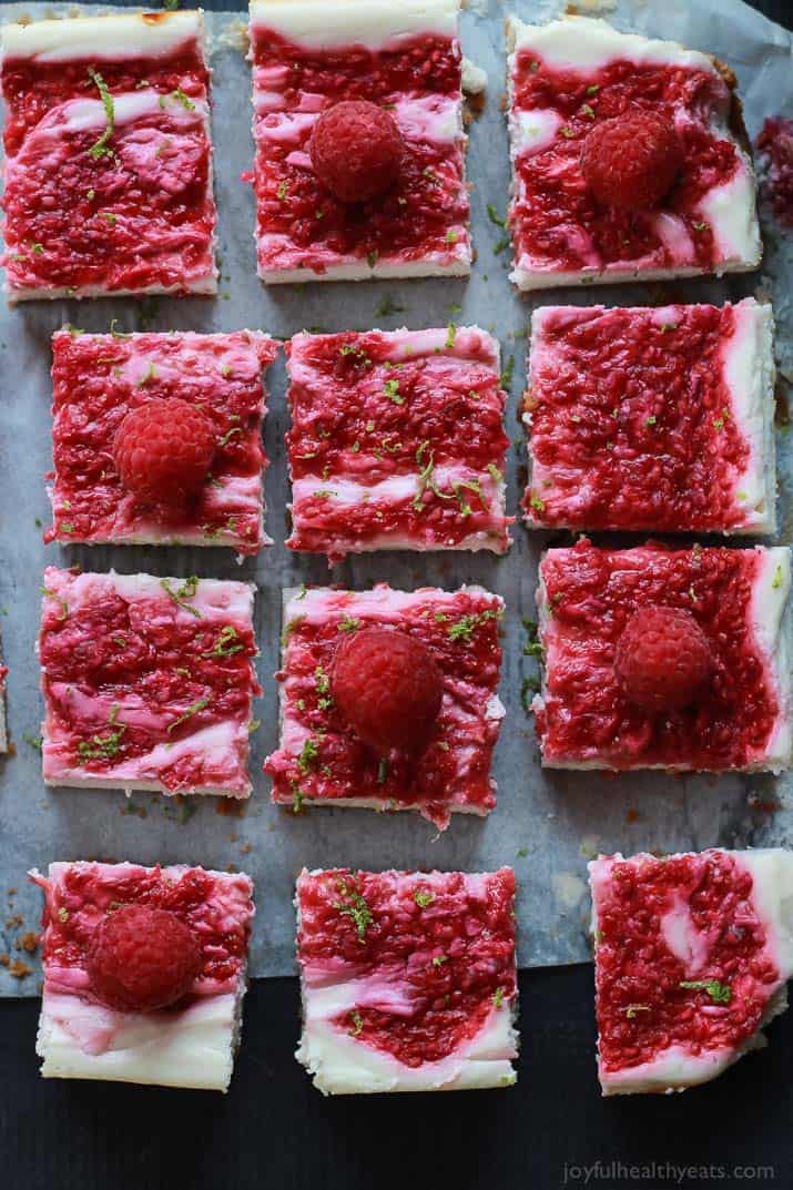 Skinny Raspberry Mojito Cheesecake Bars filled with creamy cheesecake goodness, fresh mint and lime juice, then topped with a fresh raspberry compote - only 130 calories! Perfect for summer parties! | joyfulhealthyeats.com #RaspberryDessert #Driscollsberry #ad 薄覆盆子莫吉托芝士蛋糕条充满了奶油芝士蛋糕,新鲜的薄荷和酸橙汁,然后顶部是新鲜的覆盆子果盘——只有130卡路里!非常适合夏季聚会!| joyfulhealthyeats.com #树莓甜点# driscolsberry #广告