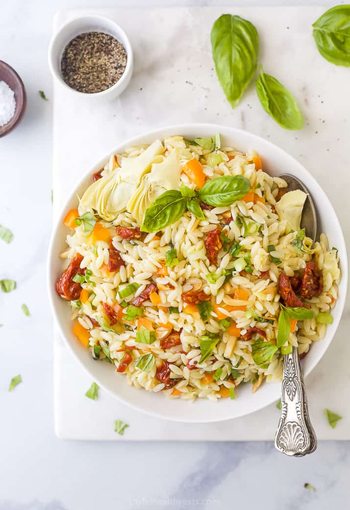 Mediterranean Orzo Pasta Salad 一碗奥罗佐沙拉在一个台面用香料和草本