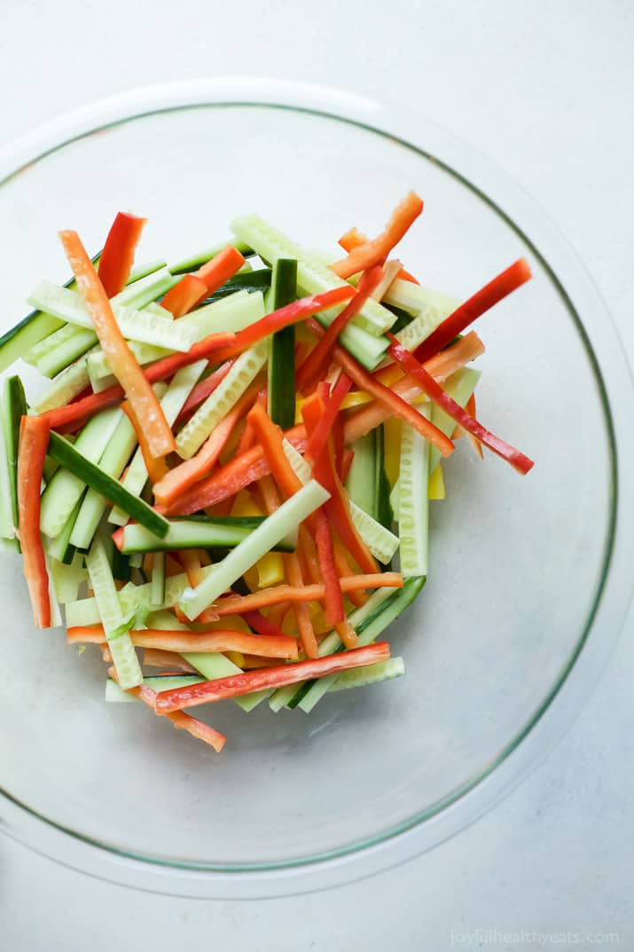 Julienned red bell peppers and cucumbers in a bowl