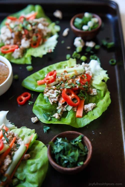 Healthy 30-Minute Dinners 三个泰式鸡肉生菜卷配辣味花生酱,放在烤盘上