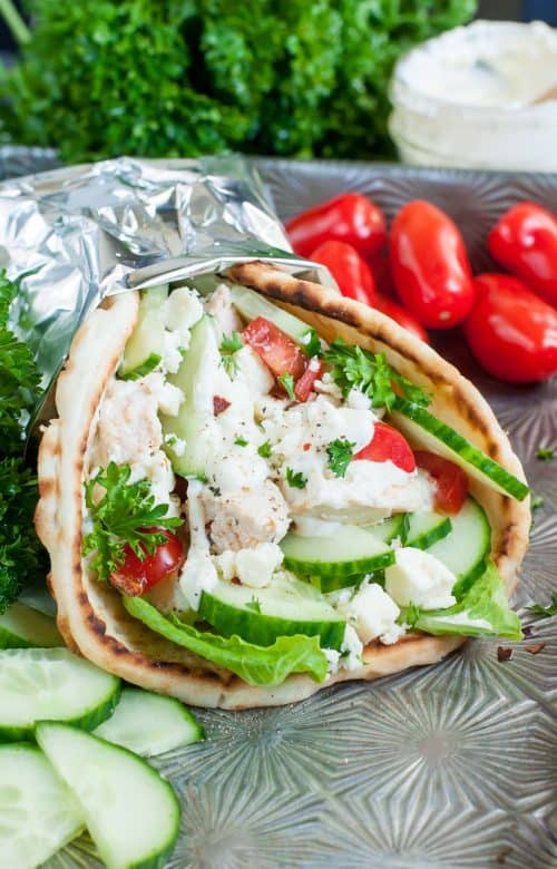 Healthy 30-Minute Dinners 用锡纸包裹的希腊鸡肉皮塔饼放在户外桌子上