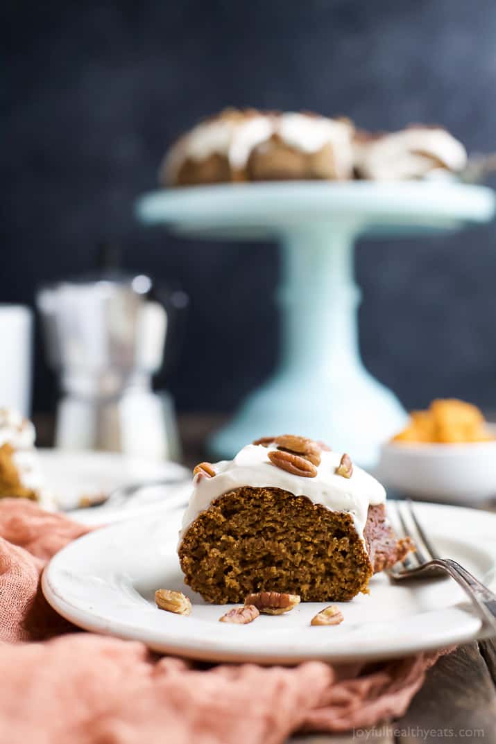 Pumpkin Bundt Cake with Cream Cheese Frosting 用叉子在盘子上放一块南瓜饼