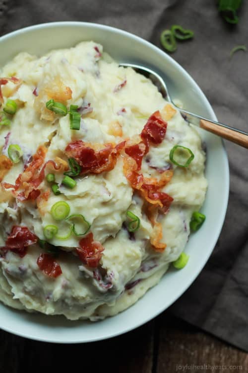 Creamy Goat Cheese Horseradish Mashed Potatoes 一碗布餐巾上的奶油山羊奶酪土豆泥,从上面拍摄