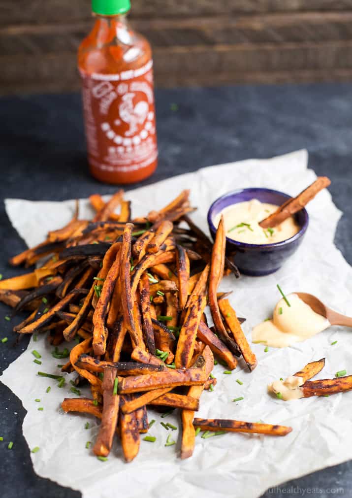Chipotle甜土豆油炸物与一杯蜂蜜sriracha aioli在羊皮纸
