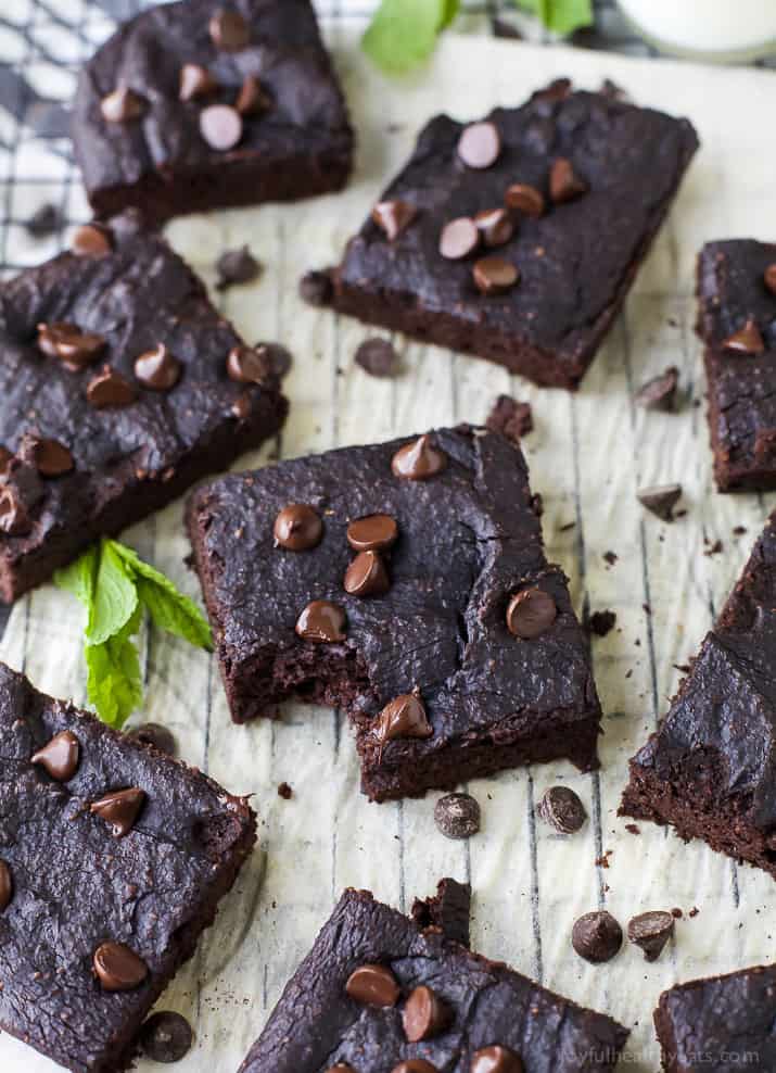 Fudgy Flourless Pumpkin Brownies 松软无面粉南瓜布朗尼安排在羊皮纸覆盖的冷却架与新鲜薄荷叶