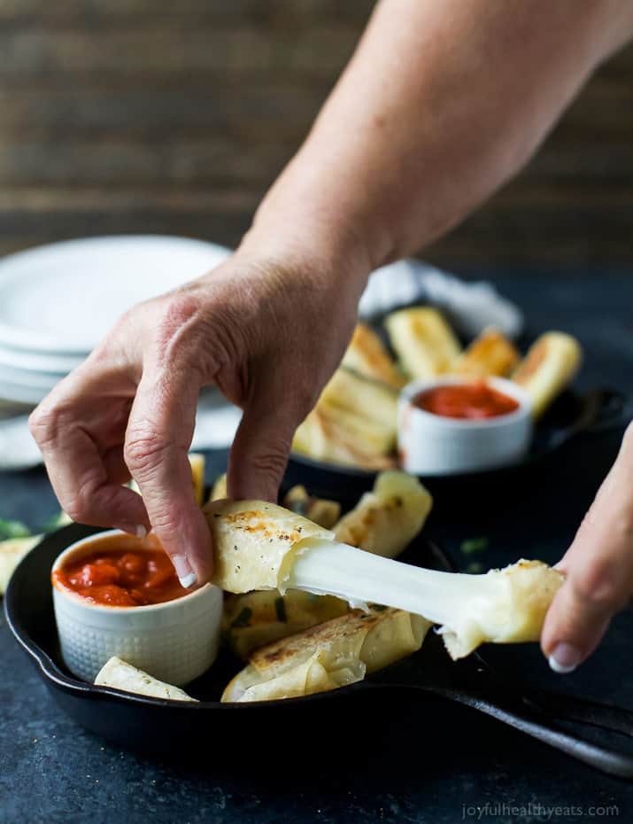 瘦烤马苏里拉奶酪棒裹着馄饨wrappers with stretchy cheese
