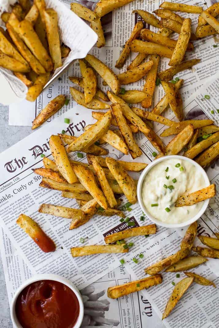 Top view of Crispy Oven Baked Fries on newspaper with a cup of roast Garlic Aioli(烤蒜泥蛋黄酱)