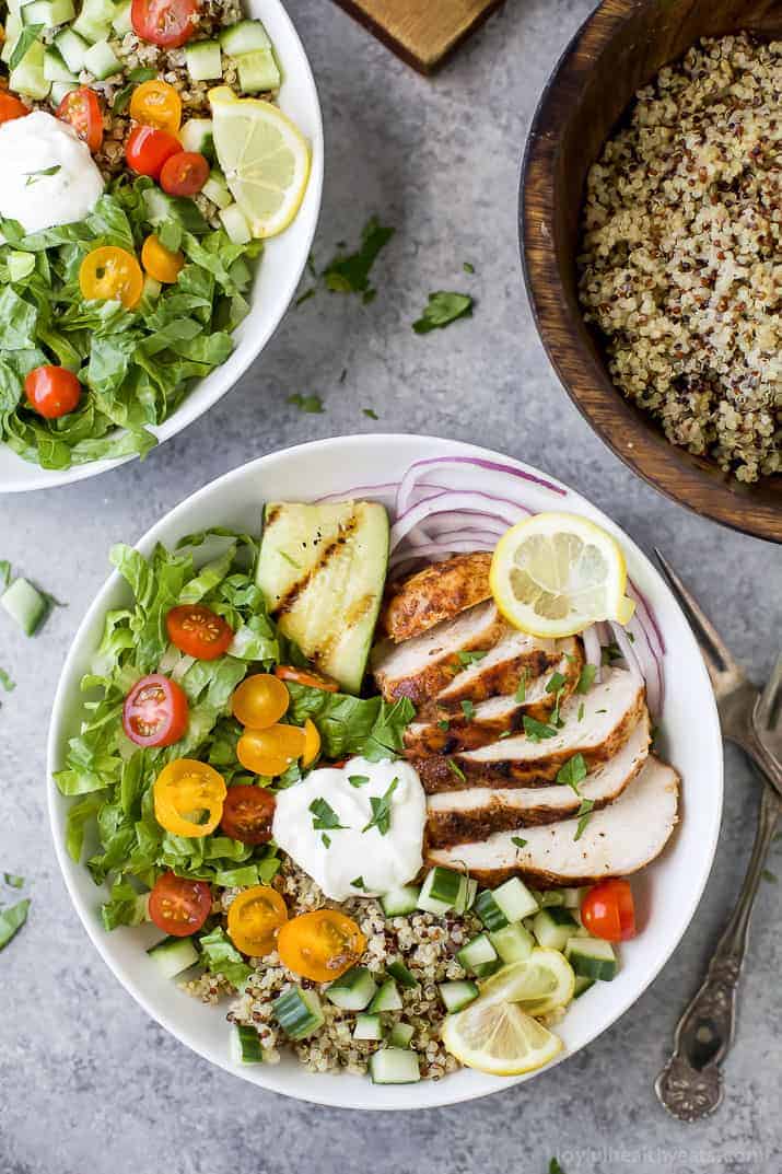Top view of a Chicken Shawarma Bowl on a bed of quinoa and lettuce and topped with Garlic Yogurt Sauce