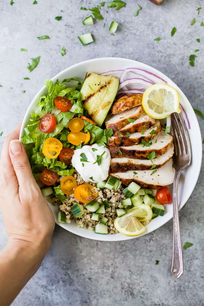 Top view of a Chicken Shawarma Bowl on a bed of quinoa and lettuce and topped with Garlic Yogurt Sauce