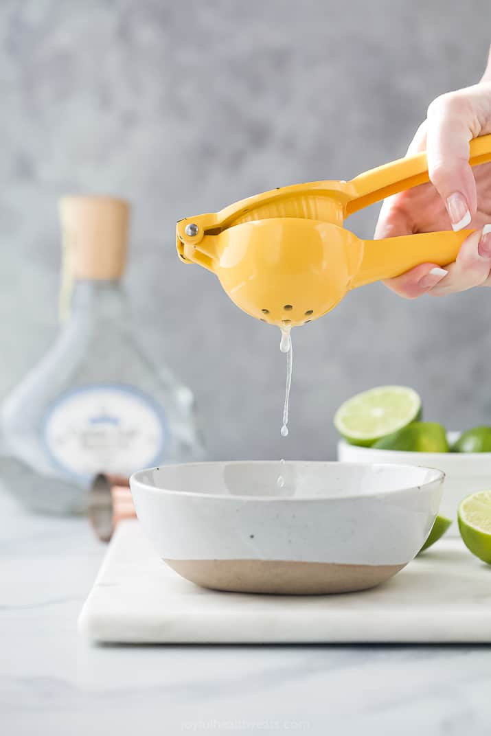 The Ultimate Skinny Margarita Recipe 芥末黄色石灰挤压器挤在碗里的石灰汁
