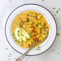 用勺子盛在碗里的土豆玉米杂烩