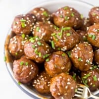亚洲肉丸堆在一个小碗里，用叉子戳其中一个
