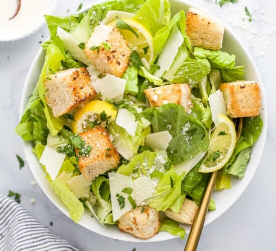 Homemade caesar salad in a bowl on a marble countertop
