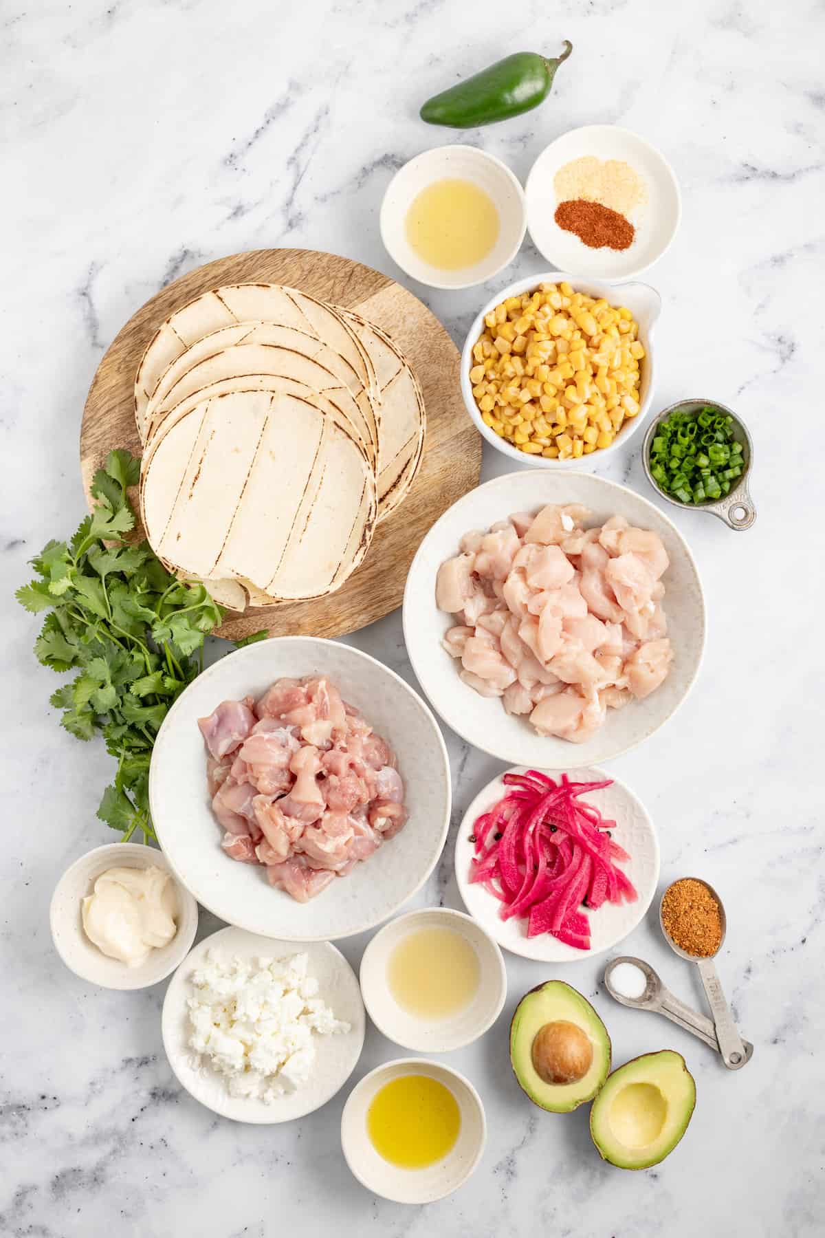 制作鸡肉玉米饼的原料，如玉米饼、生鸡肉、玉米、香草、腌洋葱和香料