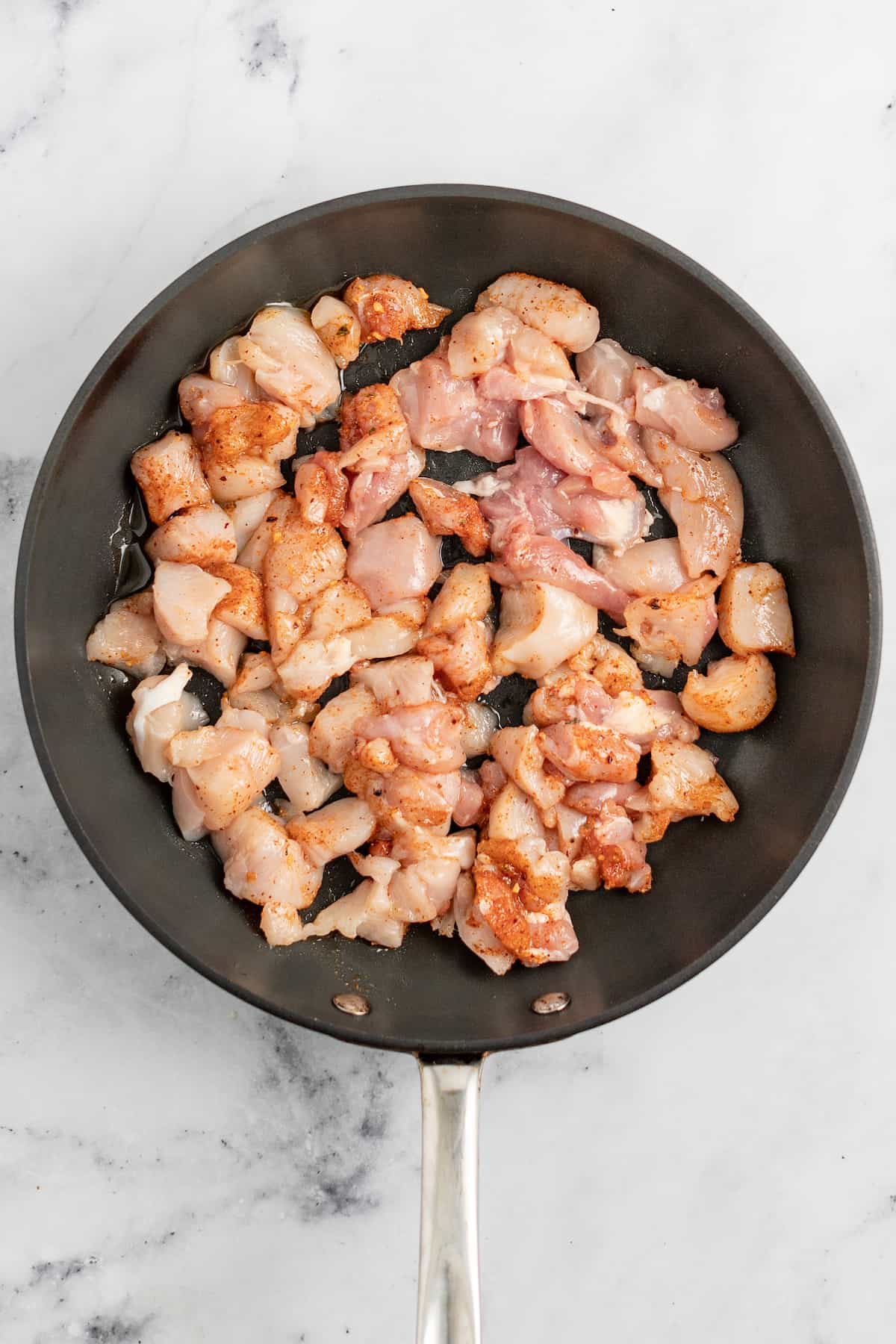 在用香料调味的煎锅里煎鸡肉